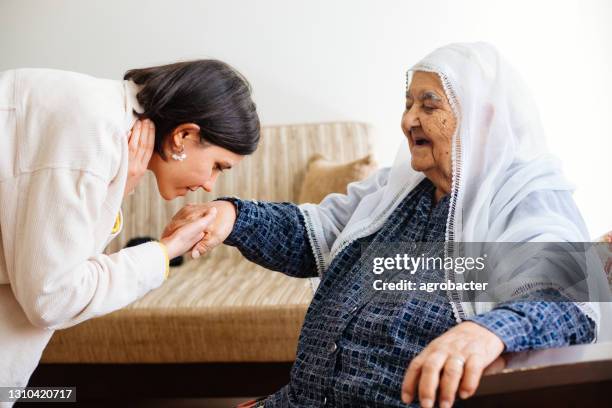 granddaugther kissing grandmother's hand - visit grandmother stock pictures, royalty-free photos & images