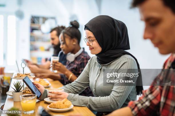 diverse people in cafe after reopening and using mobile phones - customer journey stock pictures, royalty-free photos & images