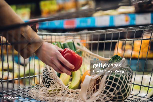 grocery shopping with reusable shopping bag at supermarket - supermercado fotografías e imágenes de stock