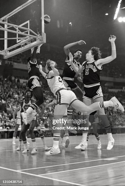 Dan Issel of the Denver Nuggets drives for a layup while Larry Kenon attempts to block the shot during an ABA game against the San Antonio Spurs at...