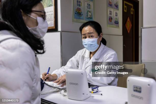 Medical workers test residents who lined up to receive the COVID-19 at a community hospital on April 2, 2021 in Wuhan, Hubei Province，China.According...