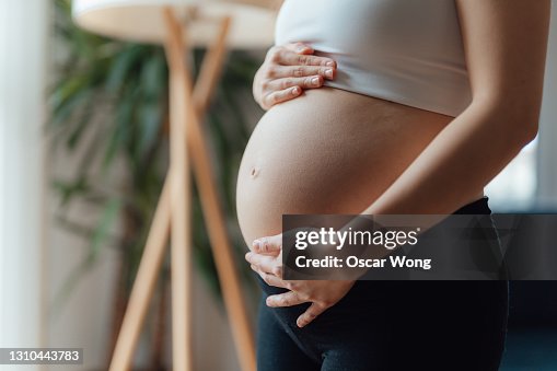 Midsection of Pregnant Woman Holding Her Belly Midsection of Pregnant Woman Holding Her Belly