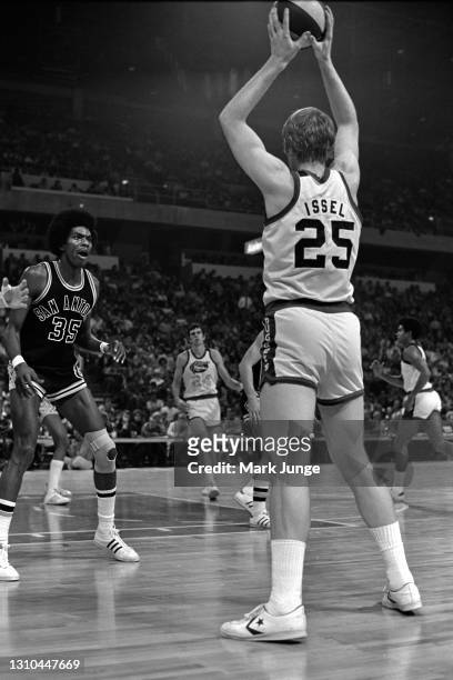 Dan Issel of the Denver Nuggets prepares to pass the ball to a cutting Bobby Jones during an ABA game against the San Antonio Spurs at McNichols...