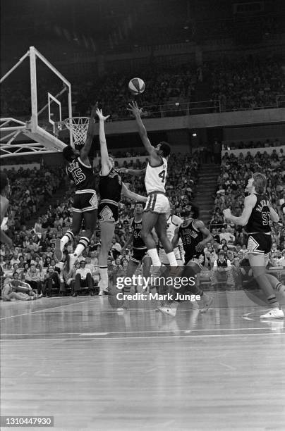 Denver Nuggets guard Ralph Simpson shoots a floater over Billy Paultz and Henry Ward during an ABA game against the San Antonio Spurs at McNichols...