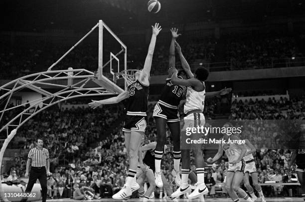 Denver Nuggets forward David Thompson shoots a jump shot over Henry Ward and Coby Dietrick during an ABA game against the San Antonio Spurs at...