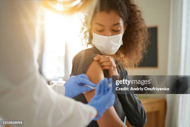 young woman getting vaccinated - medical research stock-fotos und bilder