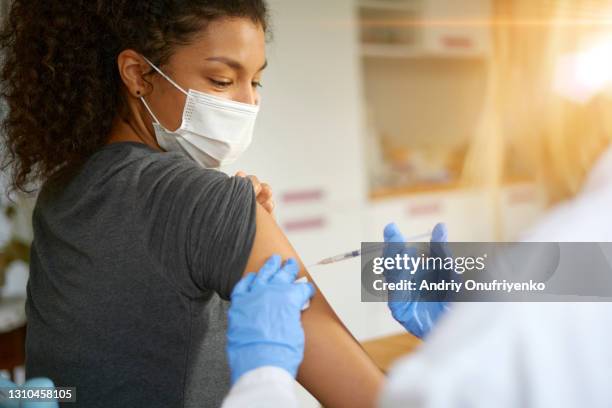 young woman getting vaccinated - injection ストックフォトと画像