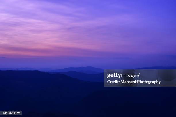 scenic colorful purple sunset in mountains range background - purple sky fotografías e imágenes de stock