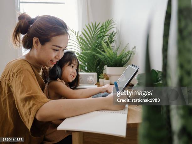 frau arbeitet von zu hause aus mit kind - die neue normalität stock-fotos und bilder