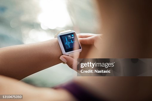 Woman Looking At Her Smart Watch for a pulse trace Woman Looking At Her Smart Watch for a pulse trace