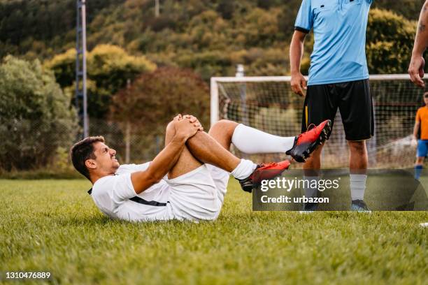 futbolista se lesionó en el juego - falta término deportivo fotografías e imágenes de stock