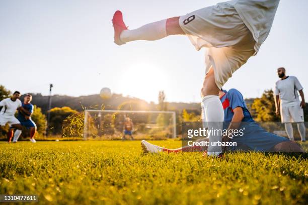 spieler gegen seinen rivalen im fußballspiel - sportliga stock-fotos und bilder