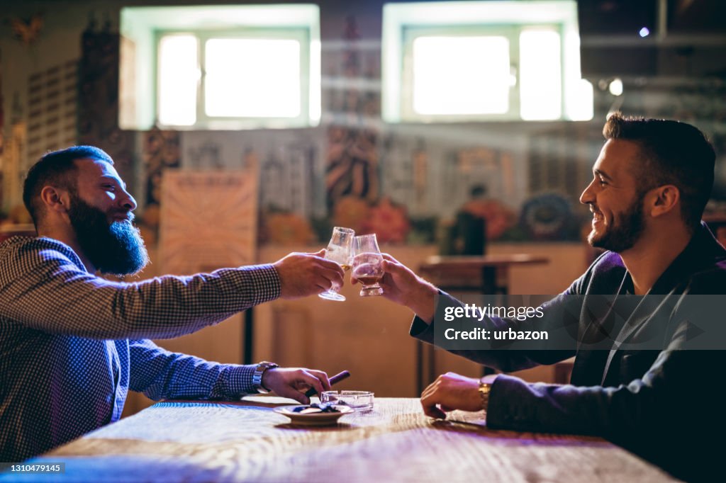 Handsome bearded men drinking whiskey