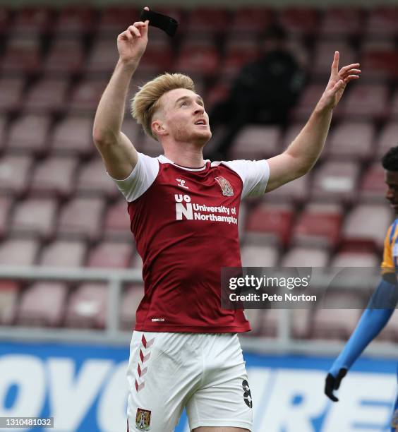 Ryan Watson of Northampton Town holds aloft his black armband as as tribute to former player Lee Collins who passed away on April 1 after scoring his...