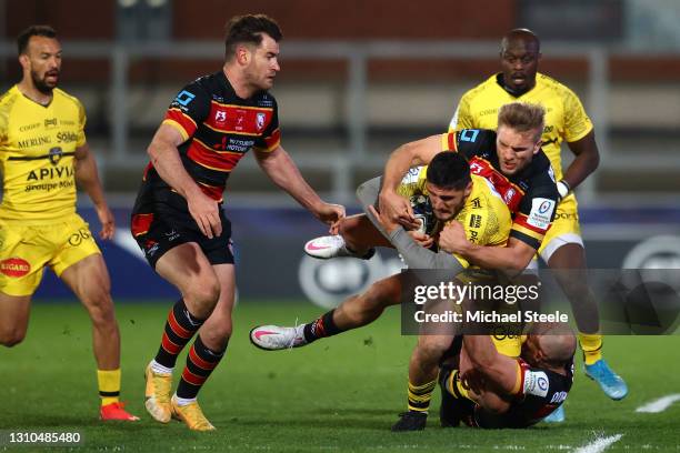 Arthur Retiere of La Rochelle is tackled by Charlie Sharples and Chris Harris of Gloucester as team mate Mark Atkinson closes in during the Heineken...