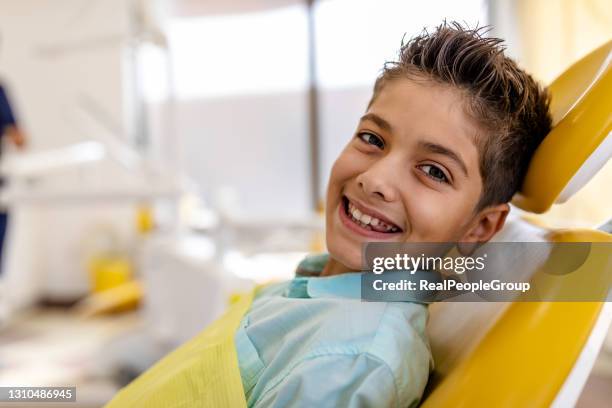 niño feliz sosteniendo un cepillo de dientes y sonriendo - dentistas fotografías e imágenes de stock