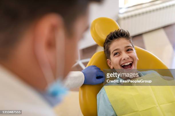 treatment of tooth loss, the child to the dentist. child in the dental chair dental treatment during surgery. - boys with braces stock pictures, royalty-free photos & images