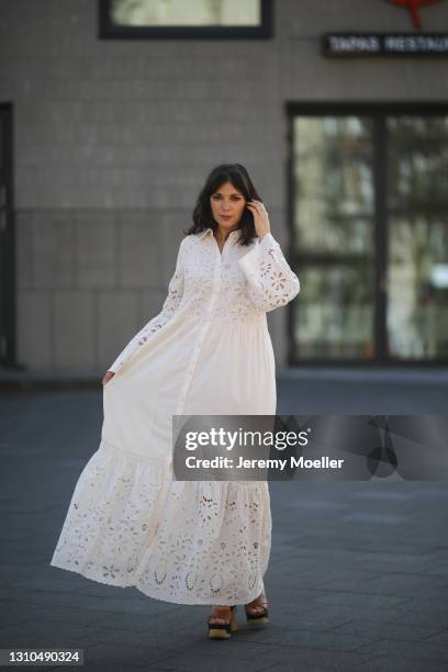 Anna Wolfers poses wearing white summer dress and wooden sole heels on March 30, 2021 in Hamburg, Germany.