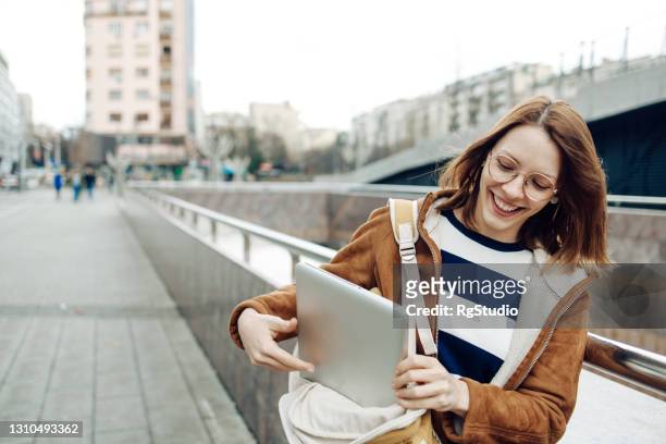 portrait of a beautiful student taking a laptop from her bag - laptop bag stock pictures, royalty-free photos & images