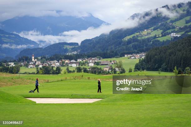一對夫婦在陰天在烏登斯高爾夫球場打高爾夫球 - golfbaan green 個照片及圖片檔