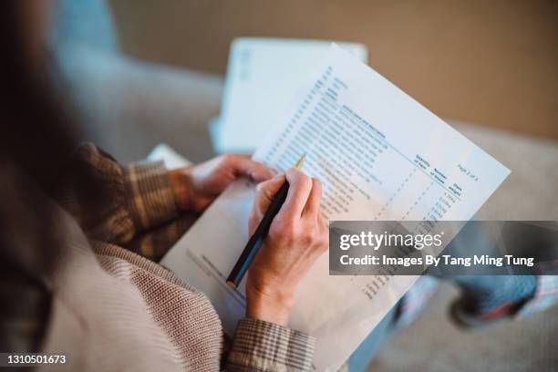 young woman moved into her new house and checking the list of new flat pack furniture - checklist stockfoto's en -beelden