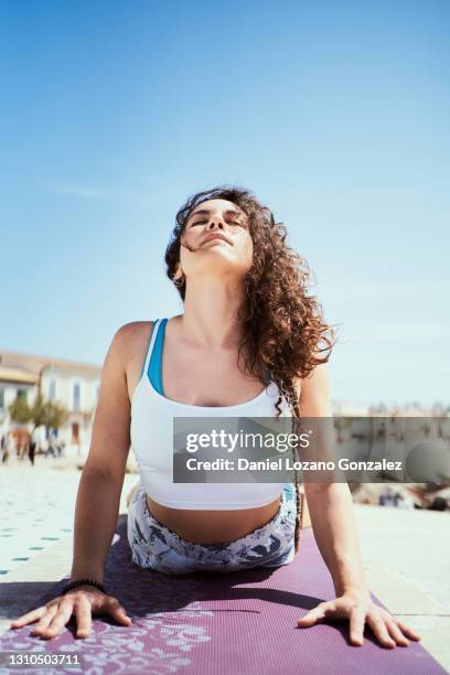 woman doing cobra yoga pose outdoors. yoga concept - cobra stretch stock pictures, royalty-free photos & images