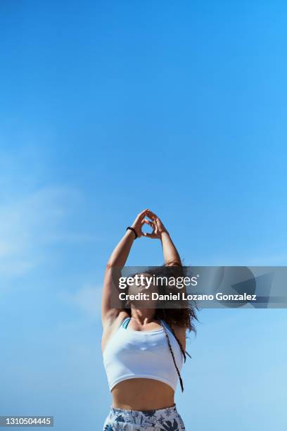 woman on a yoga pose against sky. yoga concept - yoga pose stock-fotos und bilder