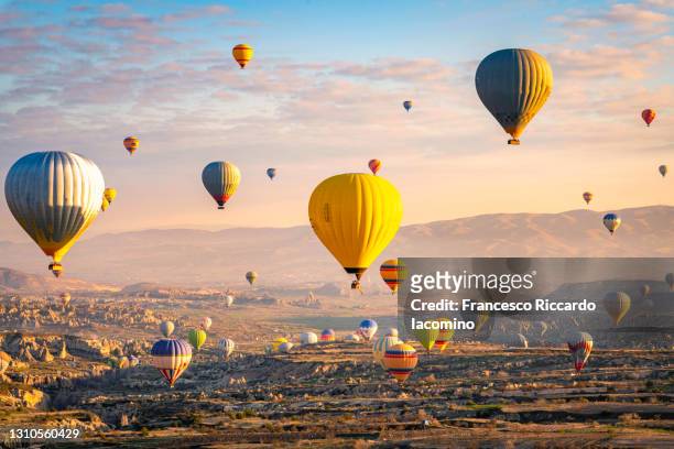 hot air balloons at sunrise. cappadocia, turkey - hot air balloon ride stock-fotos und bilder