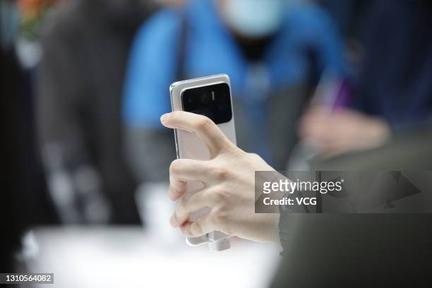 Customer tries out a Mi 11 Ultra smartphone at the 5,000th Xiaomi retail store on the opening day on April 3, 2021 in Shenyang, Liaoning Province of...