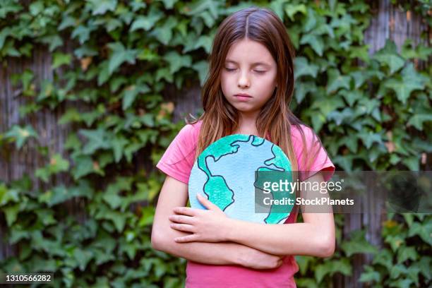 worried girl about planet earth - climate change children stock pictures, royalty-free photos & images