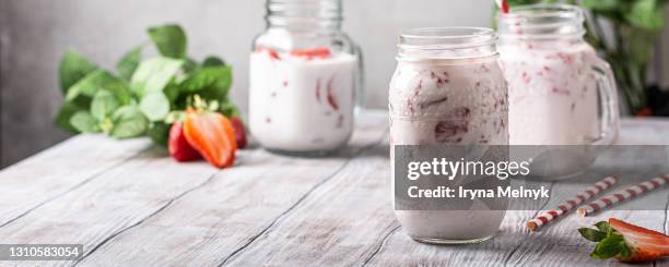 strawberry smoothie or milkshake in glass jar on white wooden rustic background, healthy food concept for breakfast or lunch with copy space. banner - rustic cocktails stock-fotos und bilder