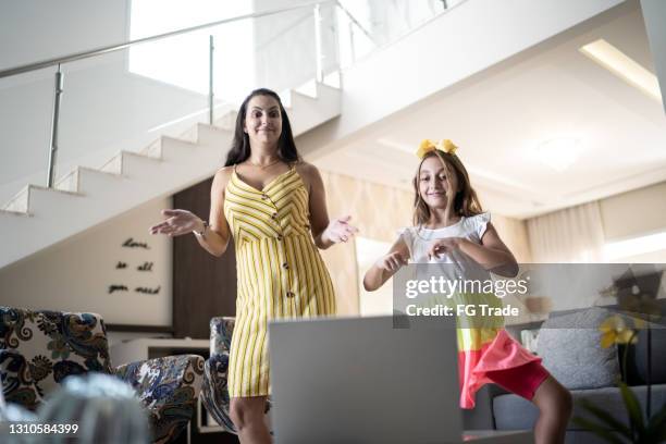 moeder en dochter die voor laptop thuis dansen - mother daughter webcam stockfoto's en -beelden