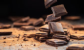 Falling broken chocolate bars on black background