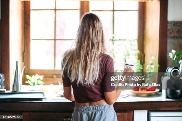 woman holding cup in the kitchen - blonde hair back stock pictures, royalty-free photos & images