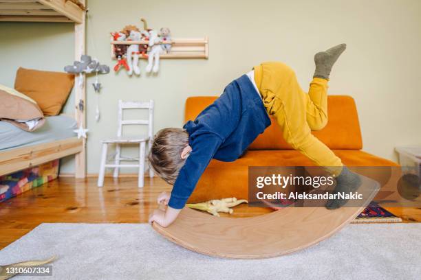 little boy's playing with balance board in his room - montessori education stock pictures, royalty-free photos & images