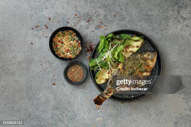 pescado a la parrilla con aderezo pesto - cocido a la parrilla fotografías e imágenes de stock