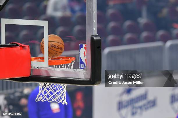 An official Spalding basketball falls through the rim next to the NBA logo on a backboard prior to the game between the Cleveland Cavaliers and the...