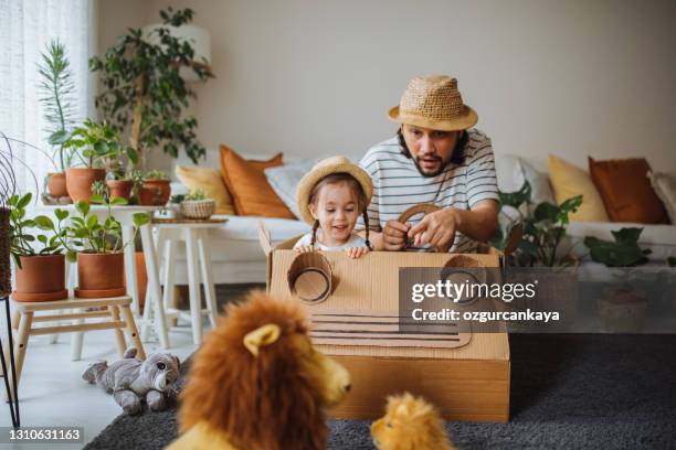 daughter and father are on safari at home with a handmade cartoncar - kid playing car imagens e fotografias de stock