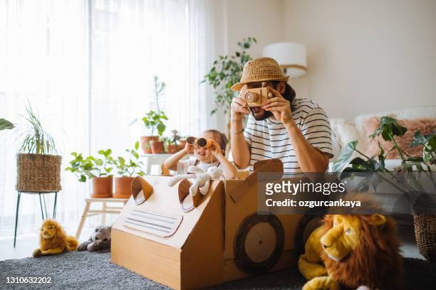 daughter and father are on safari at home with a handmade cartoncar - cardboard car stock pictures, royalty-free photos & images