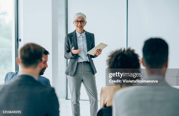 femme d’affaires donnant la présentation avec des collègues. - discours-liminaire photos et images de collection