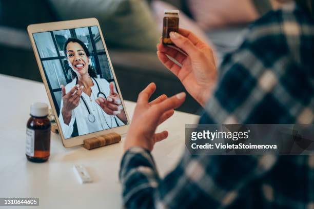 young woman video chats with doctor. - remote location stock pictures, royalty-free photos & images