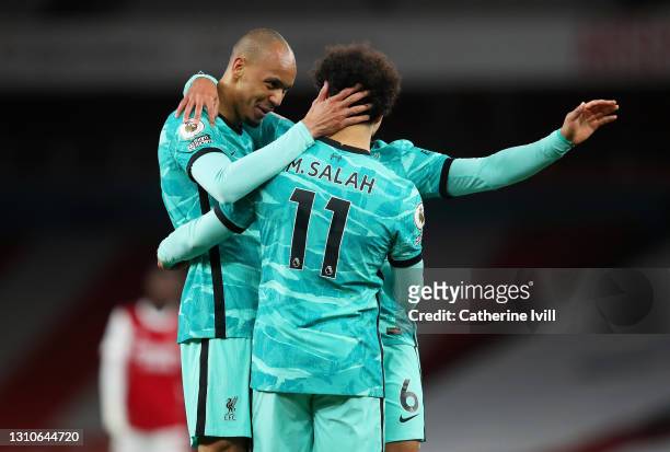 Mohamed Salah of Liverpool celebrates with teammates Fabinho and Thiago Alcantara after scoring their team's second goal during the Premier League...