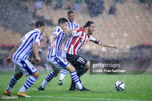 Iker Muniain of Athletic Bilbao runs with the ball under pressure from Igor Zubeldia of Real Sociedad during the Copa Del Rey Final match between...