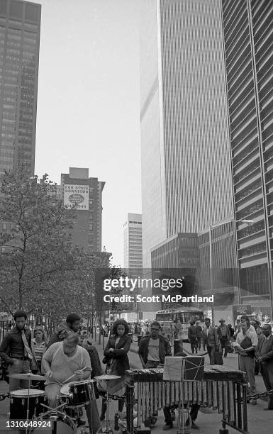 View of an unidentified street musician playing the drums for a small group of spectators on the east side of Liberty Plaza Park , New York, New...