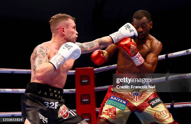 Carl Frampton of Northern Ireland punches Jamel Herring of the USA during the WBO World Super Featherweight Title Fight between Jamel Herring and...