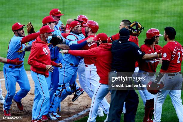 Yadier Molina of the St. Louis Cardinals goes after Nick Castellanos of the Cincinnati Reds after he slides safely into home base for a run in the...