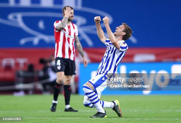 Nacho Monreal of Real Sociedad celebrates their team's victory at full-time as Inigo Martinez of Athletic Bilbao looks dejected after the Copa Del...