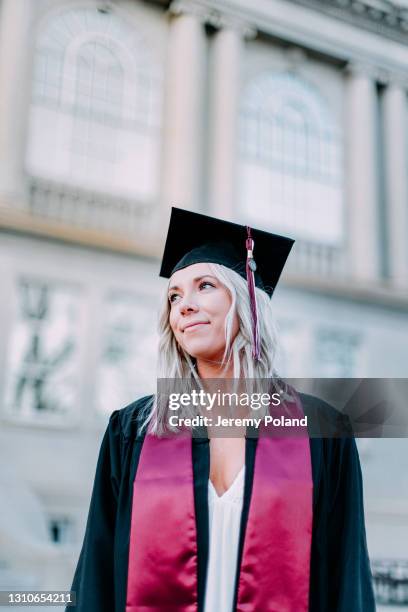 low angle portrait of a confident college university graduate with copy space - maroon graduation stock pictures, royalty-free photos & images