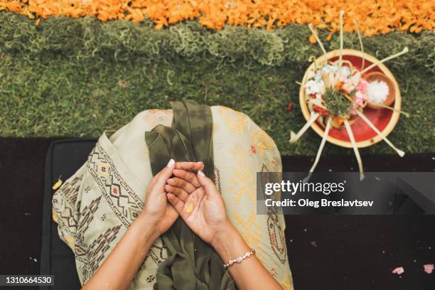 woman hands on traditional balinese ceremony with canang sari offerings to god - bali women tradition head stock pictures, royalty-free photos & images
