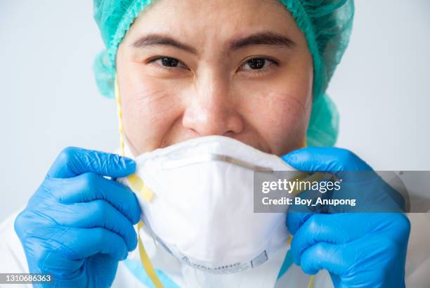 headshot of healthcare worker in ppe suit smiling behind the n95 mask while working in hospital. - mascarilla n95 fotografías e imágenes de stock